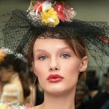 Zusätzlich zu den opulenten Kreationen von Designer Karl Lagerfeld tragen die Models Kopfschmuck mit floralen Akzenten. 