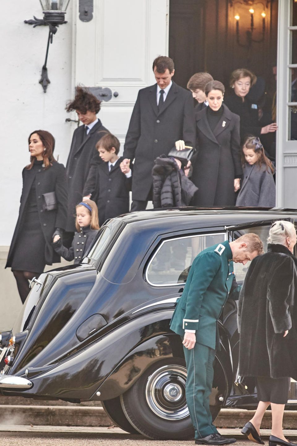 Kronprinzessin Mary mit Prinzessin Josephine, Prinz Nikolai, Prinz Henrik an der Hand von Prinz Joachim, Prinz Felix, Prinzessin Marie mit Prinzessin Athena sind auf dem Weg zur Wagenkolonne, die den Sarg von Prinz Henrik nach Kopenhagen begleitet. Links sieht man Prinz Frederik mit seinen Kindern Isabella und Christian. Am Auto steht Königin Margrethe 