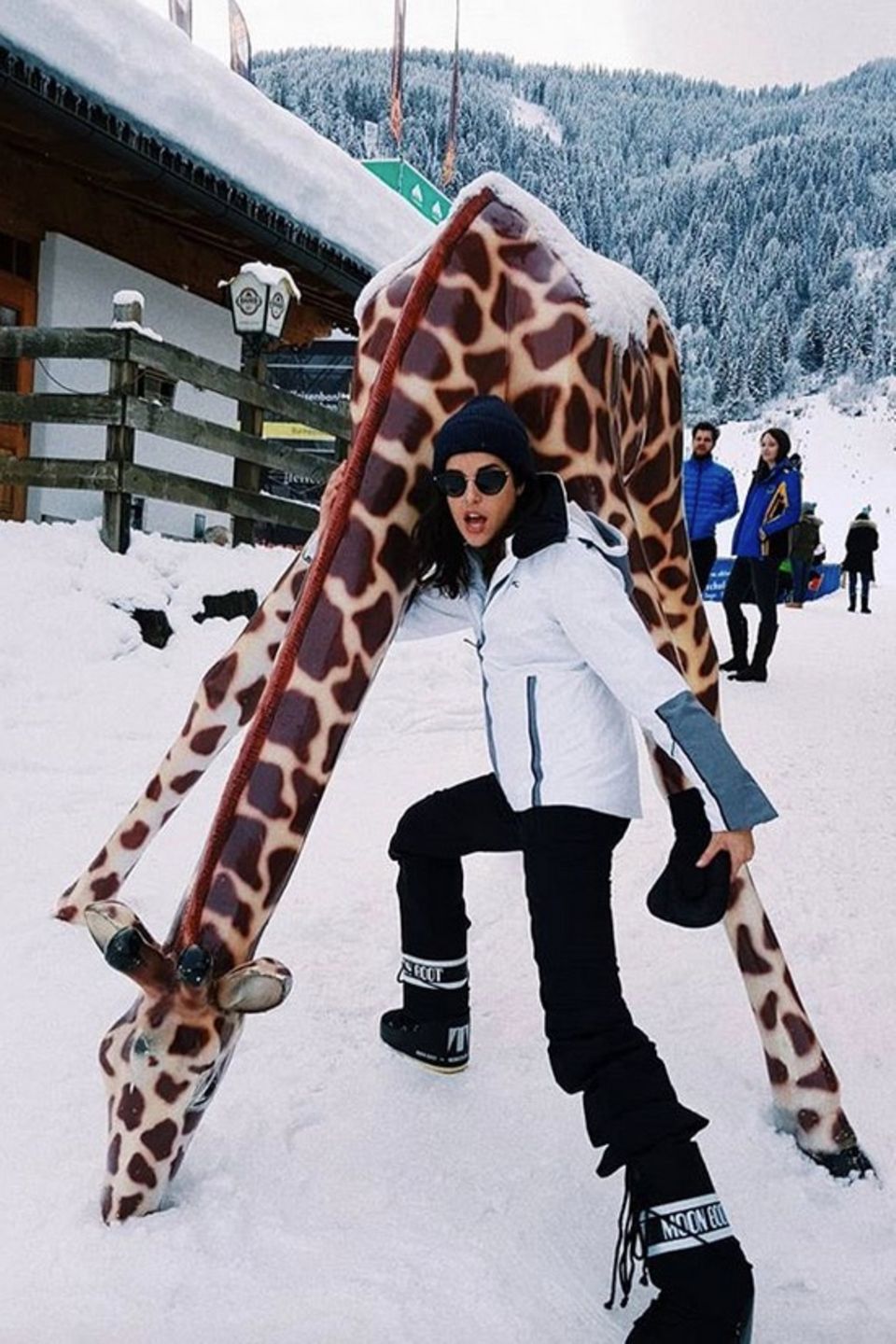 Model und Theaterdarstellerin Marie Nasemann hat sichtlich Spaß mit der Giraffe im Schnee von Kitzbühel. 