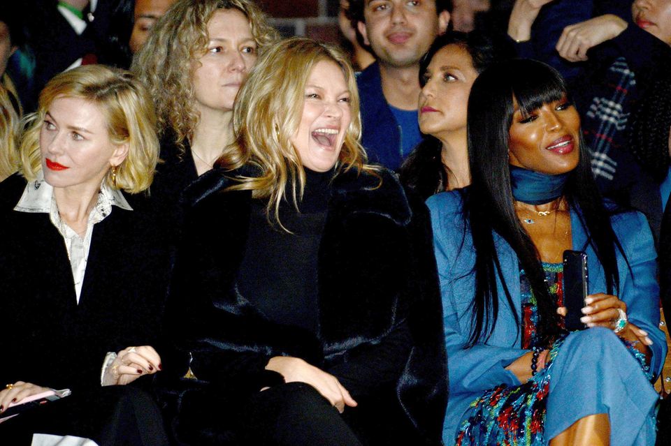 Worüber sich Kate Moss amüsiert, wissen wir nicht, dafür aber, dass noch zwei Stars neben ihr sitzen: links eine interessierte Naomi Watts und rechts ihr alte Freundin und Supermodel-Kollegin Naomi Campbell.