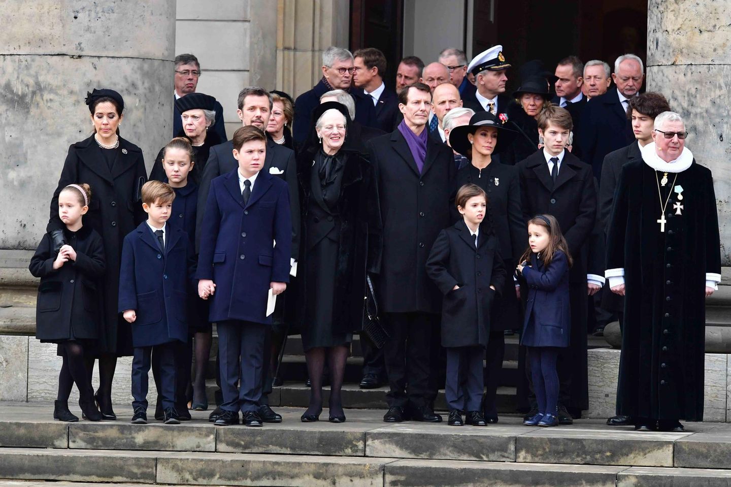 20. Februar 2018  Noch einmal reiht sich die ganze Familie auf und blickt in Richtung des Sarges, der - noch immer bedeckt von der dänischen Fahne - von der Kirche in ein Auto getragen wird.  Königin Margrethe wirkt gefasst, lächelt immer wieder ...
