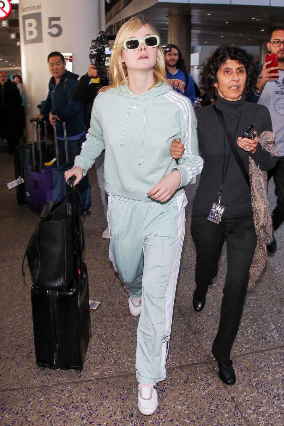 Richtig sportlich und farblich frisch zeigt sich Elle Fanning am LAX im mintgrünen Adidas-Anzug.