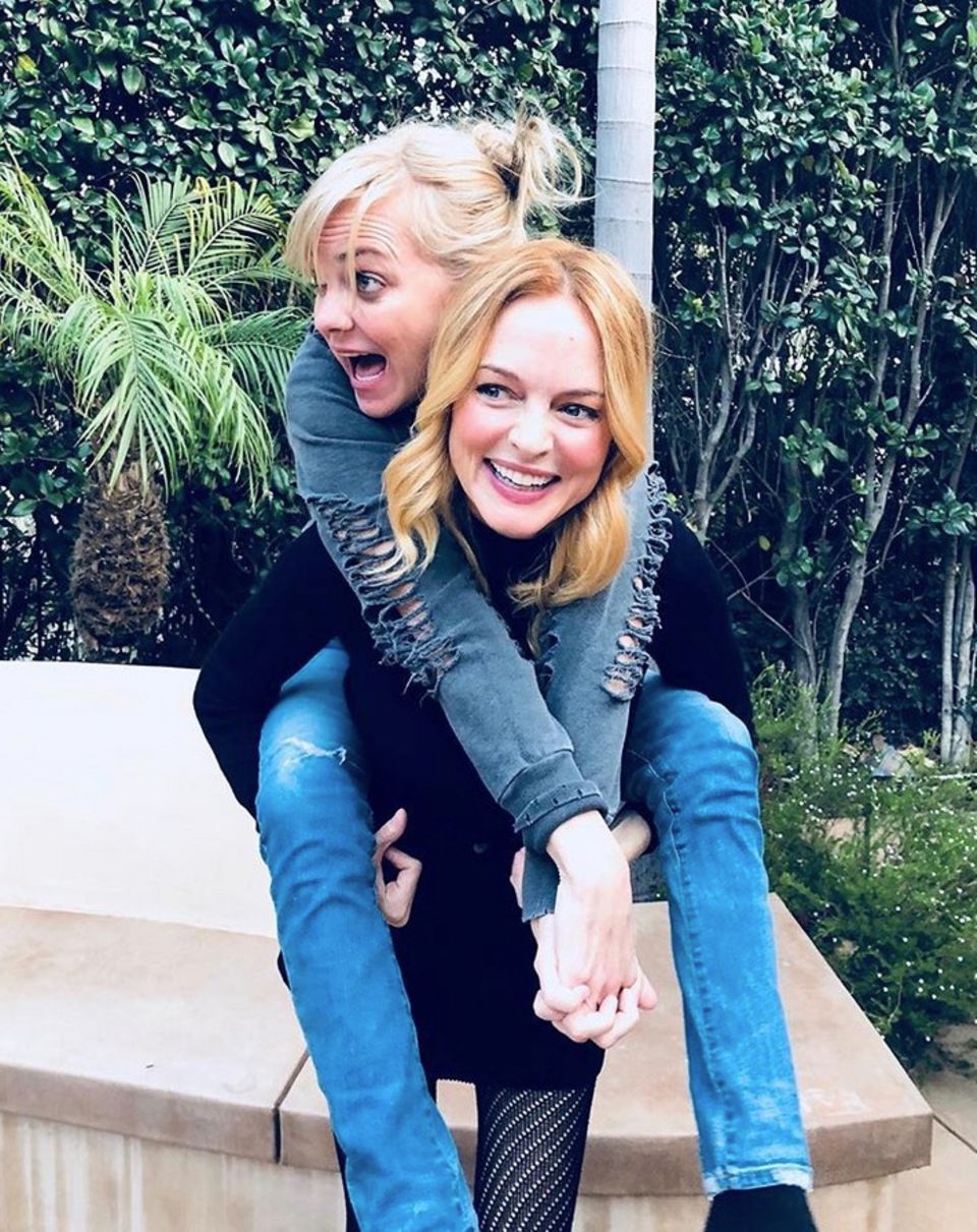 Heather Graham trägt ihre Freundin Anna Faris huckepack. Die beiden Freundinnen sind gerade dabei einen gemeinsamen Podcast aufzunehmen. Heather Graham trägt ihre Freundin Anna Faris huckepack. Die beiden Freundinnen sind gerade dabei einen gemeinsamen Podcast aufzunehmen.