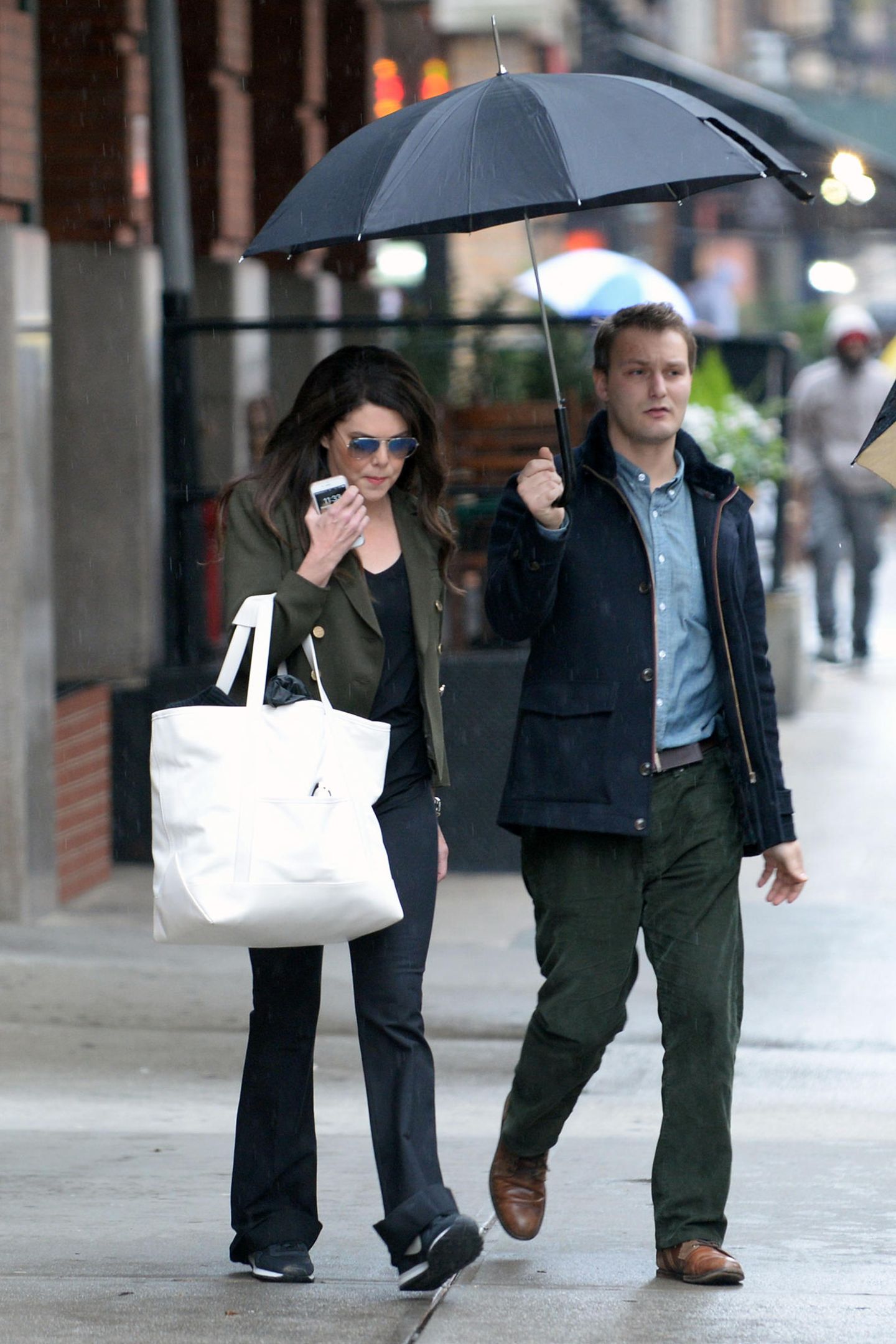 "Gilmore Girls"-Star Lauren Graham bahnt sich den Weg durch verregnete New Yorker Straßen mit freundlicher Unterstützung ihres schirmtragenden Assistenten.
