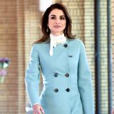 Tagsüber trägt Königin Rania einen hellblauen Mantel aus der Herbst/Winter-Kollektion 2017 von Salvatore Ferragamo. An der Taille wird er durch doppelreihige Knöpfe zusammengehalten, unten hat er hohe Schlitze. Dazu trägt sie ein helles Halstuch und hellblaue Pumps. 