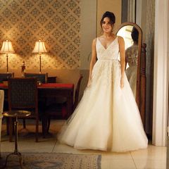 In der Serie "Suits" schlüpft Meghan Markle in ihrer Rolle als Rachel Zane in ein Brautkleid von Designerin Anne Barge. Es überzeugt durch einen V-Ausschnitt mit feinen Trägern, einen taillierten Schnitt und aufwendige Stickereien auf Tüll. Eigentlich eine passende Kreation für eine angehende Prinzessin.