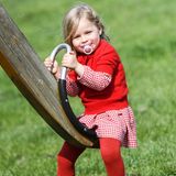 In einem karierten Kleid und farblich abgestimmten Pullover und Strumpfhose strahlt Celeste Trussardi auf dem Spielplatz. Auch wenn die Outfits der beiden Schwestern an diesem Tag sehr unterschiedlich sind, so tragen sie beide dieselben Schuhe.
