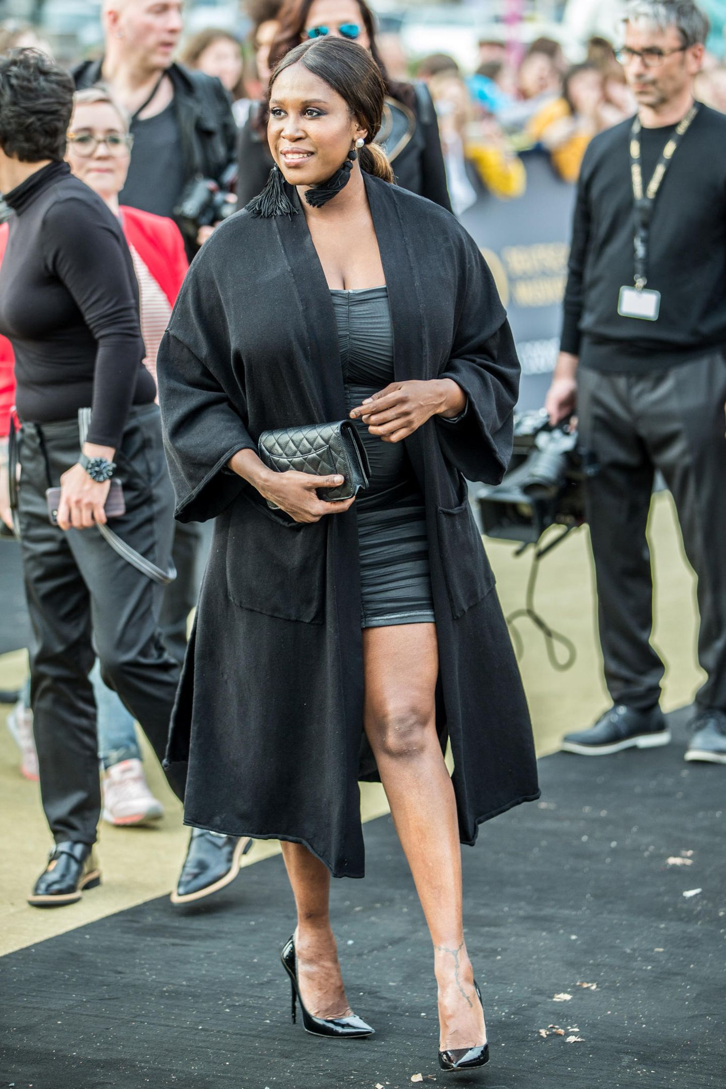"Let's Dance"-Star Motsi Mabuse verdeckt ihr grau-schwarzes Mini-Kleid und damit auch ihren Babybauch zu Beginn der Echo-Verleihung noch mit einem schwarzen Mantel.