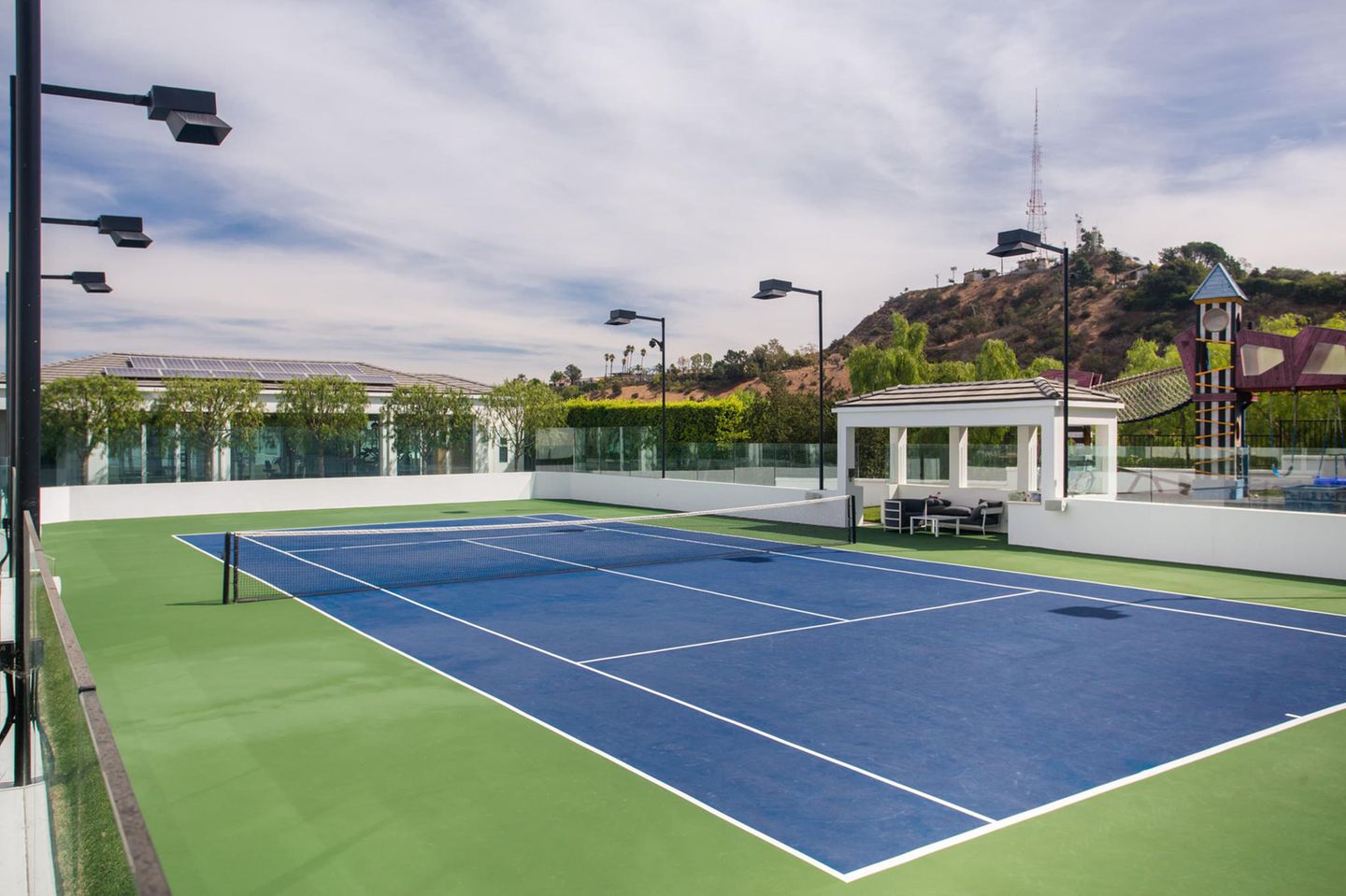 Auf dem Außenbereich des Hauses befindet sich auch ein großer Tennisplatz. 
