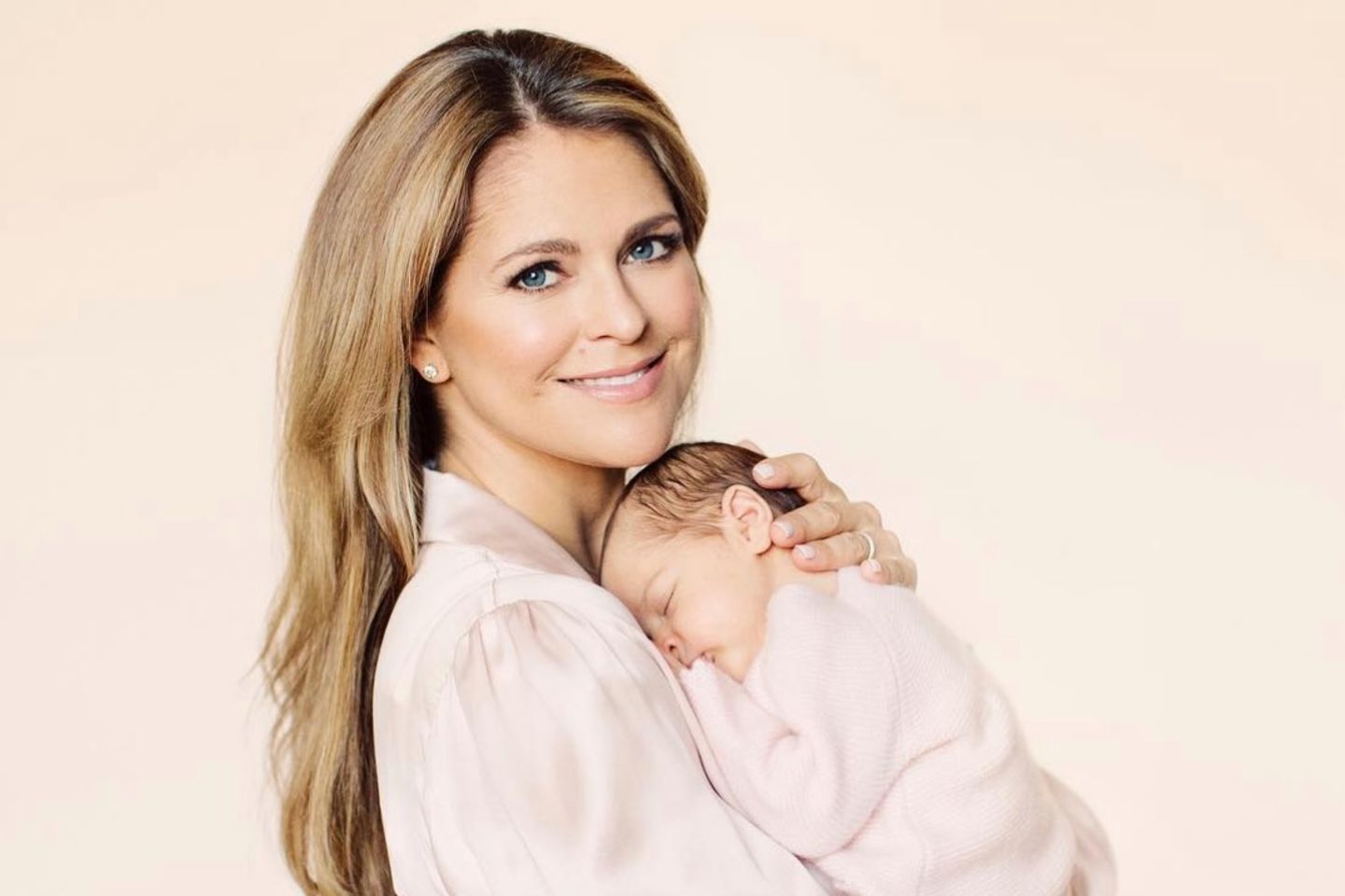27. April 2018  Mamas ganzer Stolz: Prinzessin Madeleine posiert für die Fotografin in einer blassrosa Bluse. Tochter Prinzessin Adrienne schmiegt sich schlafend an Mamas Brust. Familienglück pur! 