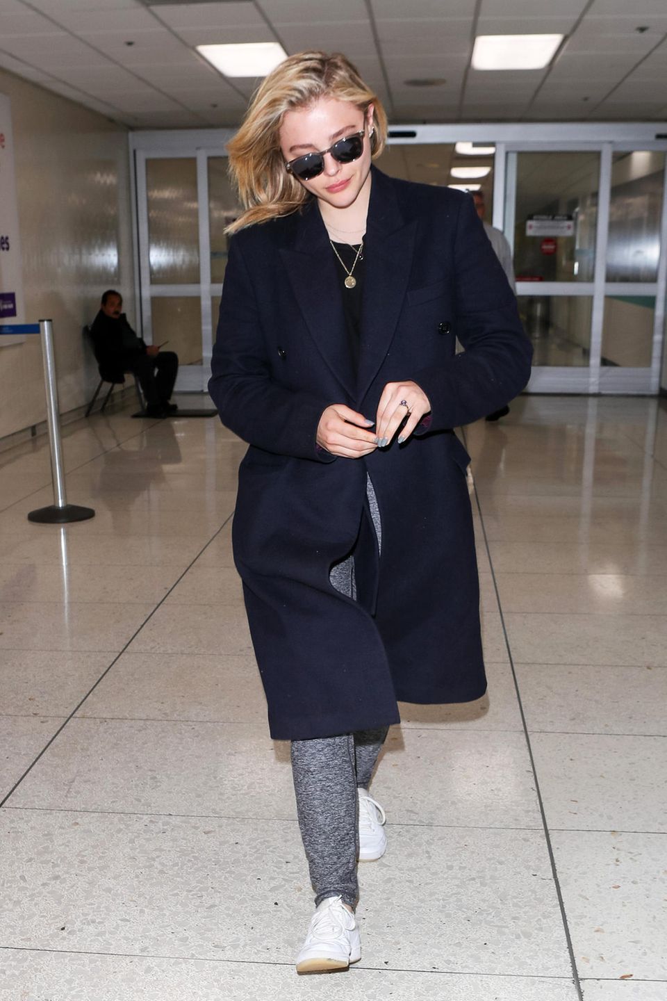 Auch wenn der dunkelblaue Mantel von Chloë Grace Moretz recht elegant wirkt, die graue Jogginghose lässt sich darunter auch nicht gänzlich verstecken.