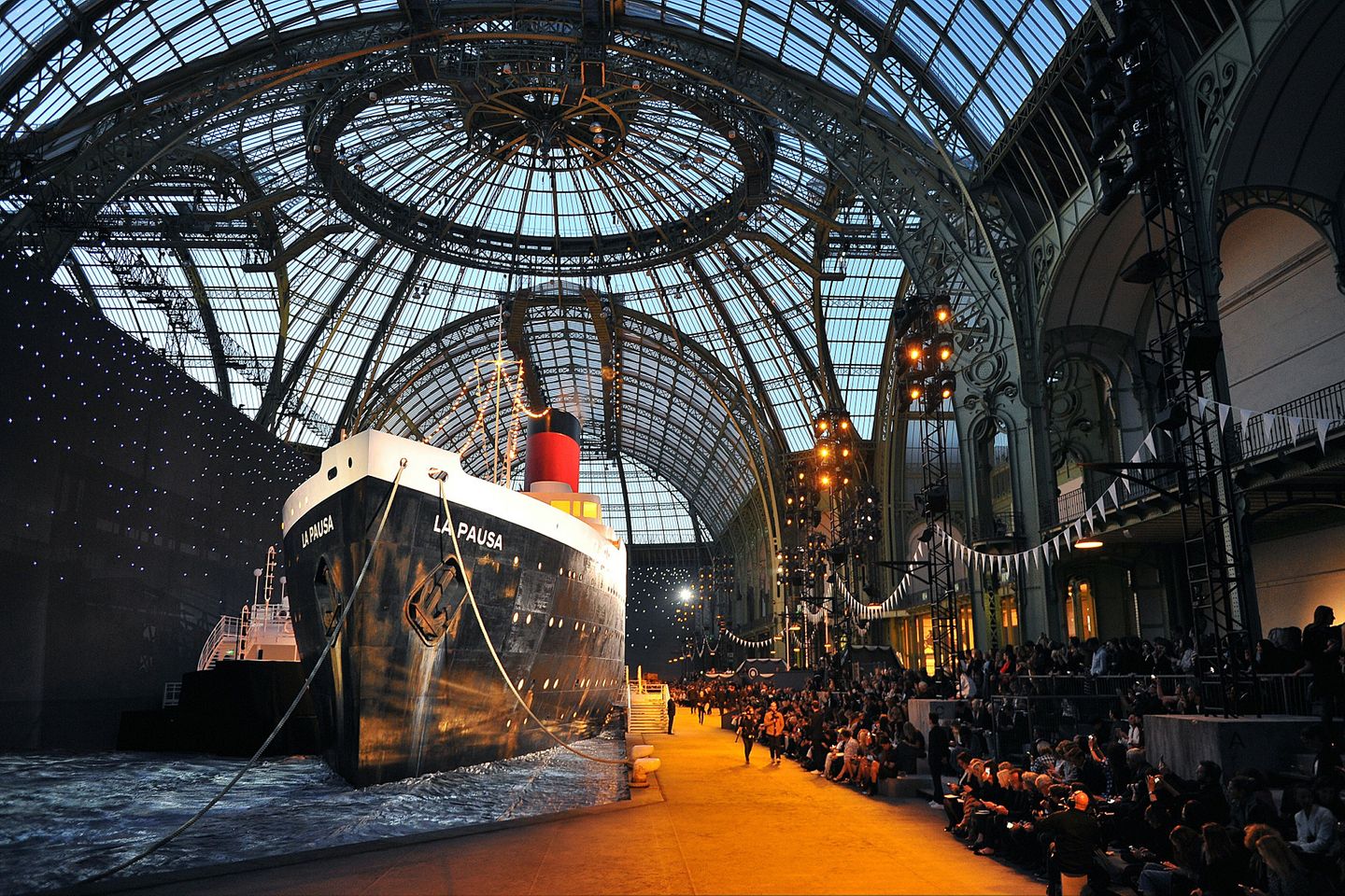 Karl Lagerfeld überrascht jedesmal aufs Neue mit den Kulissen, die er für seine Kollektionen im Pariser Grand Palais entwirft. Diesmal nimmt er seine Gäste passend zur Präsentation der neuen Cruise Collection mit auf Kreuzfahrt.