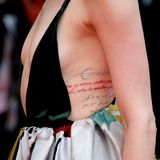 Das Kleid der schönen Schauspielerin gewährt tiefe Einblicke - auch auf die feine Kalligrafie ihrer Tätowierungen ... 