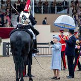 12. Mai 2018  Die Queen hat den Freizeitlook mit Kopftuch gegen ein offzielleres Outfit mit Hut getauscht und waltet ihres Amtes bei der "Royal Windsor Horse Show". Ein Mitarbeiter hält schützend einen Schirm über die 92-Jährige, die aber wohl eher eine Leiter bräuchte, um den Pokal zu überreichen.