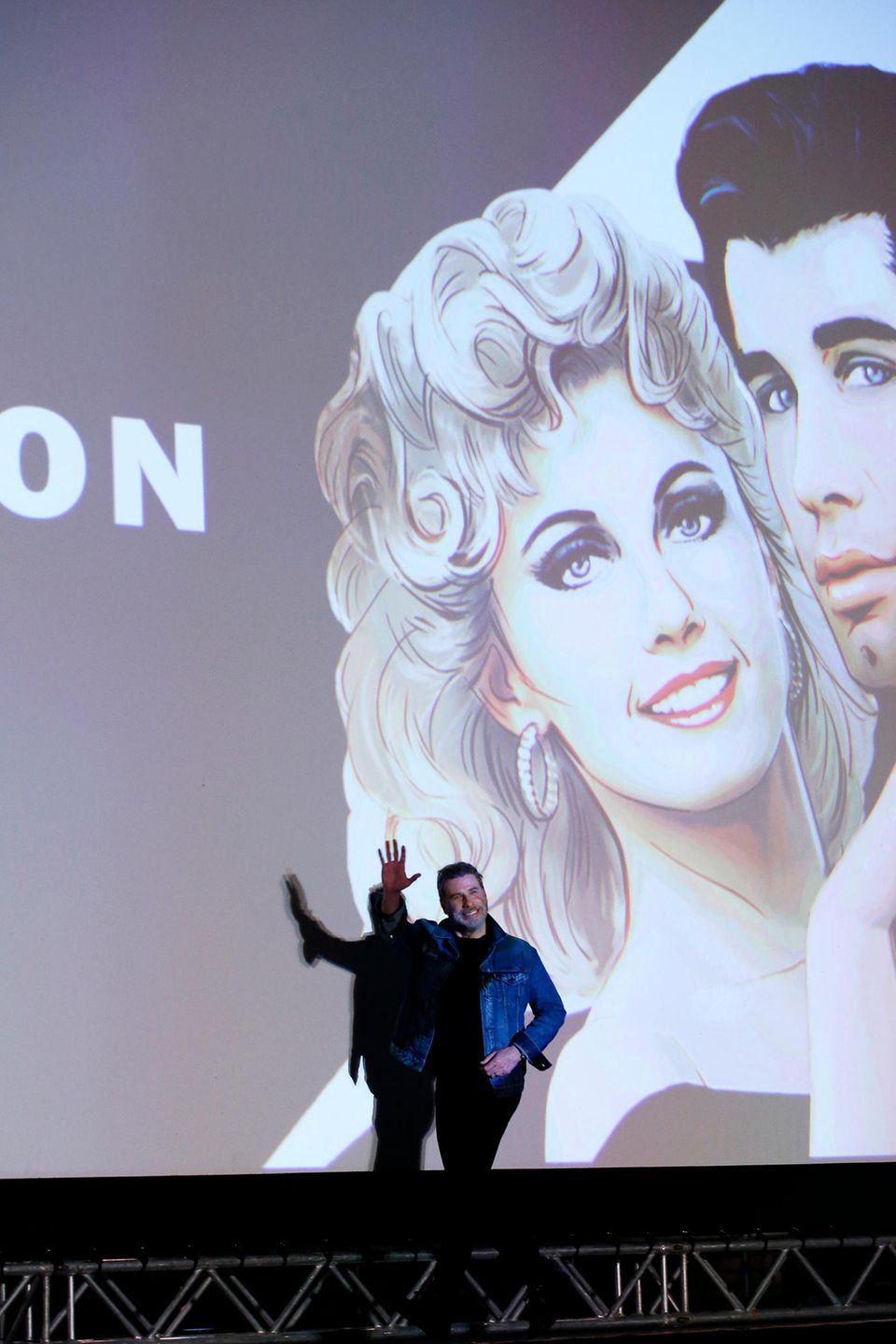 Hollywoodstar John Travolta  winkt den Zuschauern zu. Am Strand von Cannes wird sein Klassiker "Grease" aufgeführt. Mehr als genug Grund zum Anlass gibt es, schließlich ist der Kultfilm 40 Jahre alt geworden.