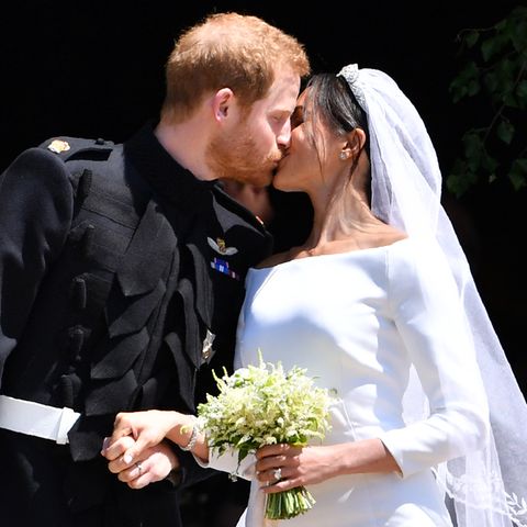 Nicht auf einem Balkon sondern direkt vor der Kirche küssen sich Harry und Meghan - ein bisschen zu kurz, finden die Fans.