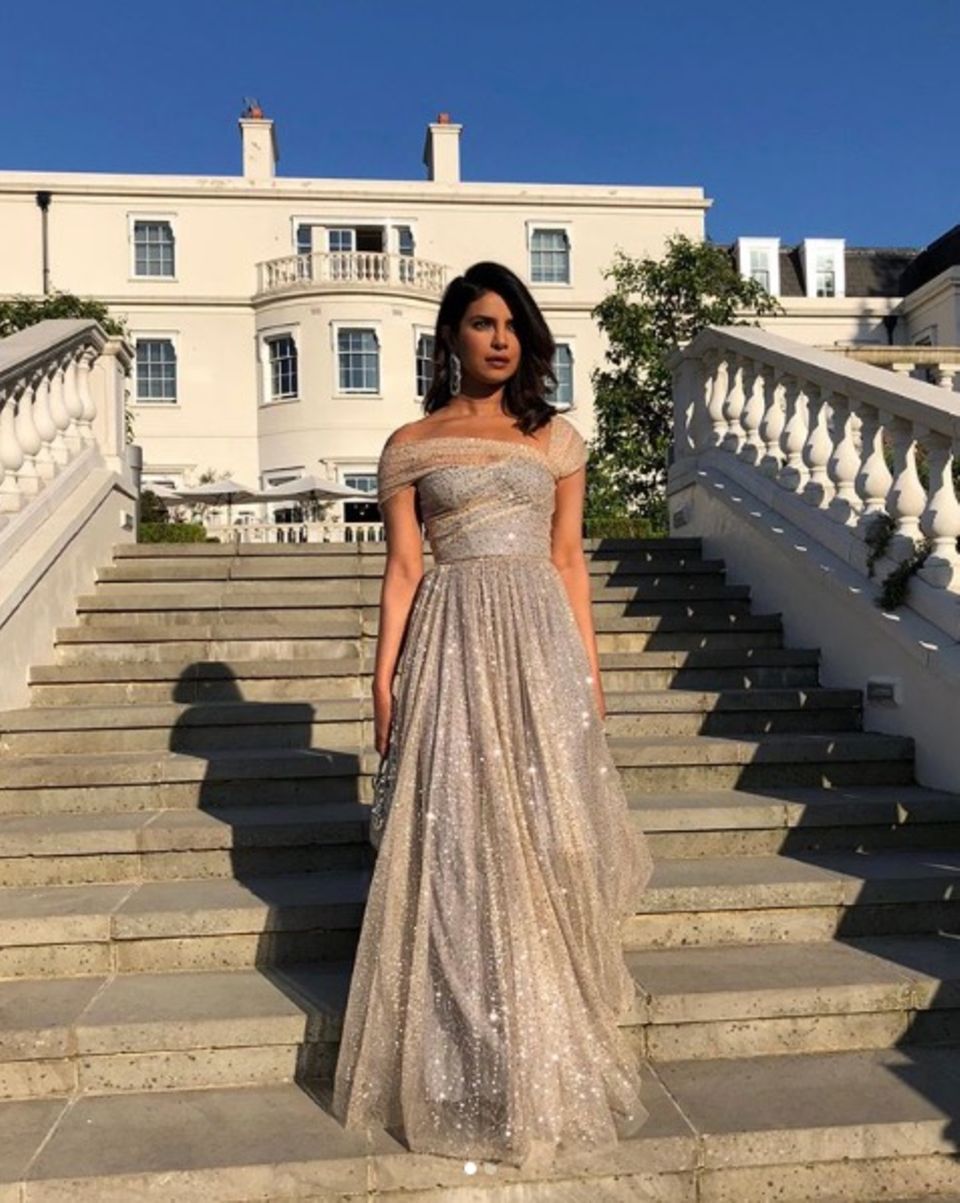 Auch Priyanka Chopra nutzt die Zeit vor der Party und die Treppen vorm Hotel, um ihren zweiten Weddinglook zu präsentieren. Im Sonnenlicht funkelt ihr Couture-Kleid von Dior besonders schön.