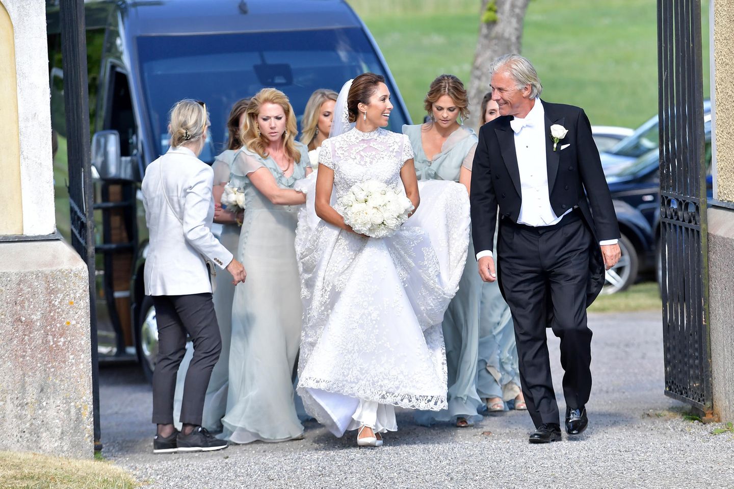 2. Juni 2018    Im wunderschönen Spitzenkleid schreitet Louise "Lussan" Gottlieb mit ihrem Vater und den Brautjungfern zur Kirche von Trosa. Prinzessin Madeleine passt auf, dass dem Schleier nichts passiert.