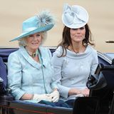 2012  Im darauffolgenden Jahr scheint sich die strahlende Herzogin mit ihrer Stief-Schwiegermutter abgestimmt zu haben: Beide tragen zarte Grau- und Grüntöne sowie auffällige Hüte. Der extravagante U-Boot-Ausschnitt ihres Kleides wird von ihrem Fascinator fast in den Schatten gestellt. 
