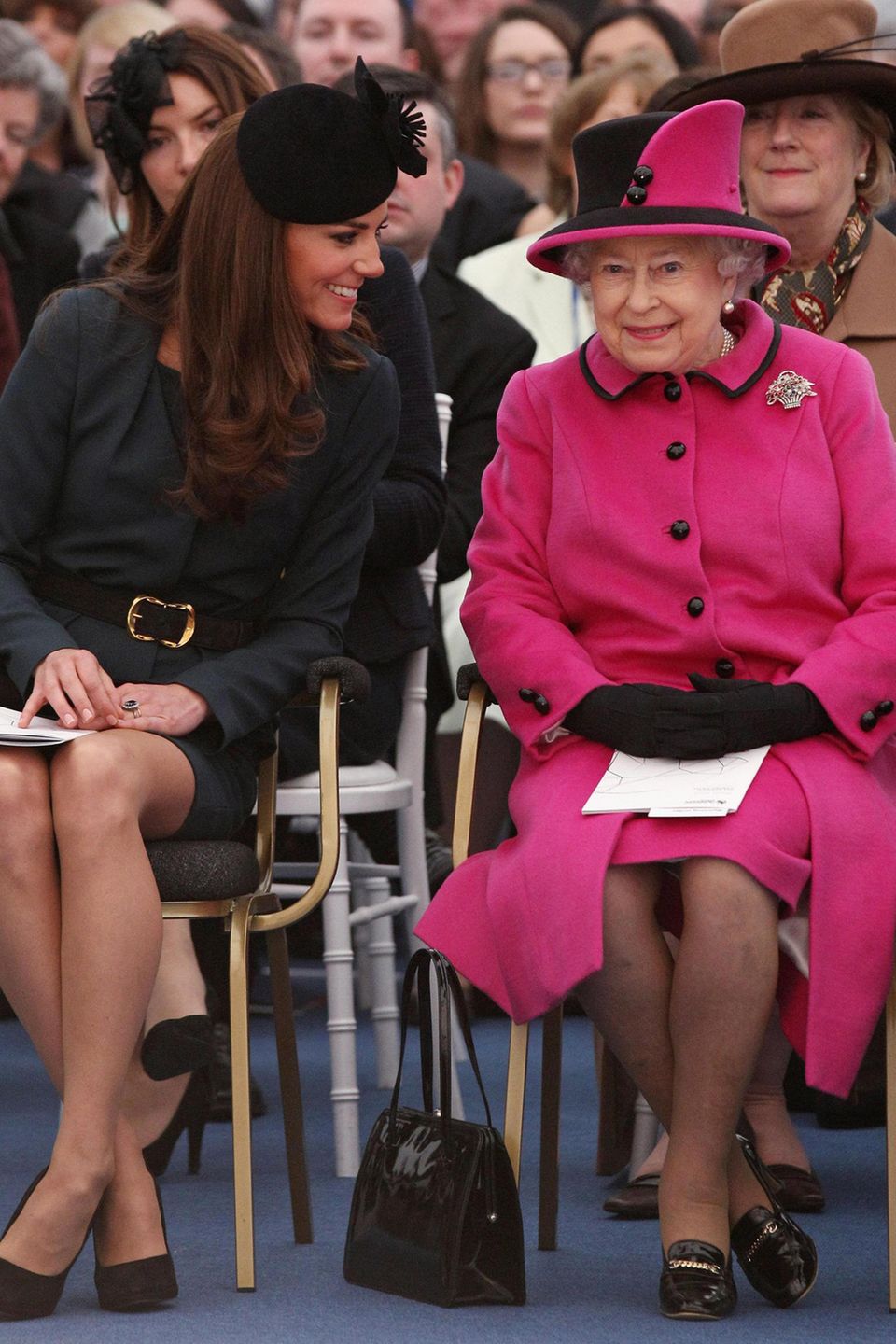 An der Seite von Herzogin Catherine scheint sich die Queen deutlich wohler zu fühlen. Die Tasche steht gut sichtbar auf der rechten Seite.
