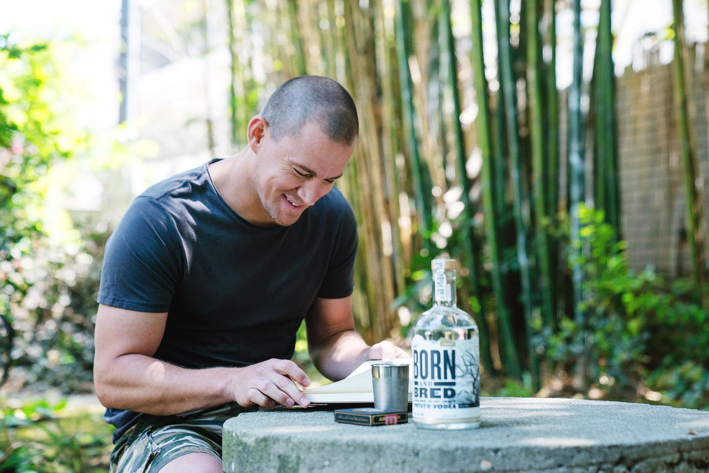 Dieses stimmungsvolle Foto verrät uns drei interessante Dinge! Erstens: es gibt nicht nur "Craft Beer", es gibt auch "Craft Wodka". Zweitens: Hollywoodstar Channing Tatum vertreibt nun eine Craft Wodka Marke (Born and Bred), und drittens: er scheint sich gerne am helllichten Tage im Park, beim Zeitunglesen einen Schluck Wodka aus einem Blechbecher zu genehmigen - oder was will uns das Werbefoto damit sagen?