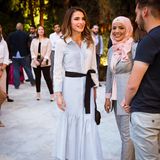 Ihrem karierten Hemdkleid verleiht Königin Rania mit einem Seidenband eine feminine Form und erzeugt damit gleichermaßen einen farblichen Kontrast.