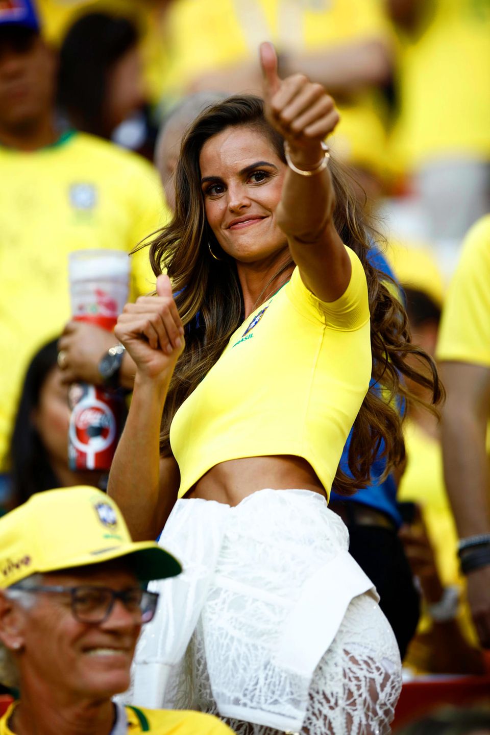 Daumen hoch für diesen Look! Das brasilianische Topmodel Izabel Goulart feuert ihre Mannschaft im Gruppenspiel gegen Serbien im Moskauer Spartak-Stadion nicht nur im knappen, gelben CBF-Trikot an, sondern auch mit einem ganz besonderen Luxus-Outfit.
