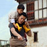 1. Juli 2018   Eine tolle Momentaufnahme zwischen einem Vater und seinem Sohn: König Jigme Khesar Namgyel Wangchuck trägt seinen neugierigen Sohn Jigme Namgyel Wangchuck auf den Schultern und scheint zu erklären, wie die Reisernte funktioniert.