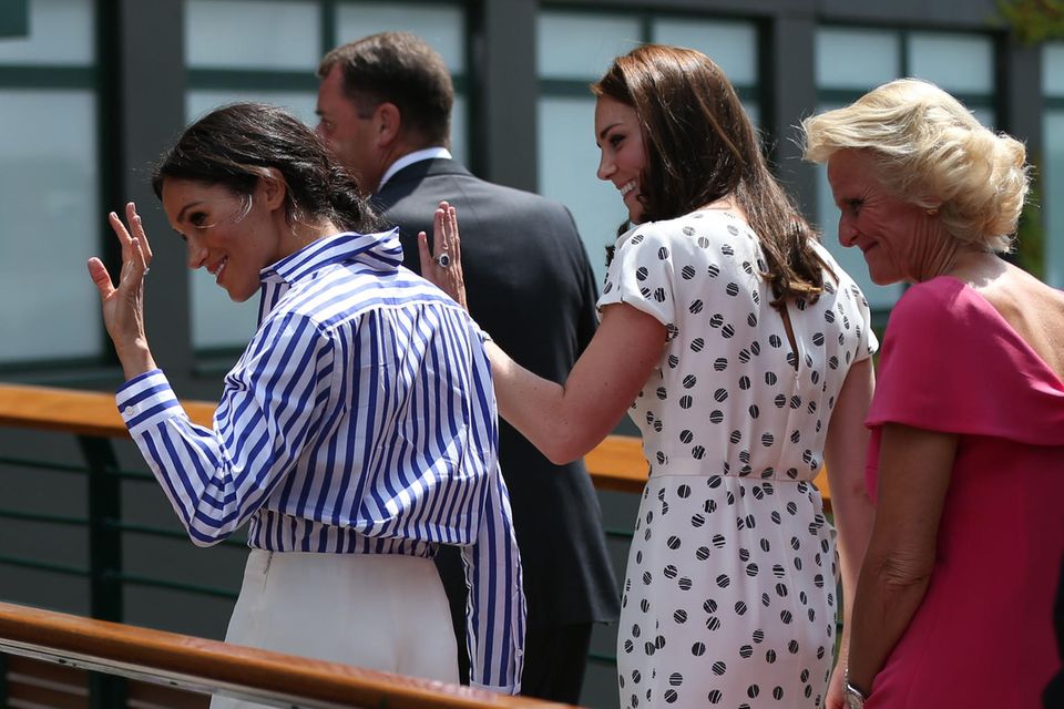 Winkend begrüßt das royale Duo die Fans in Wimbledon.