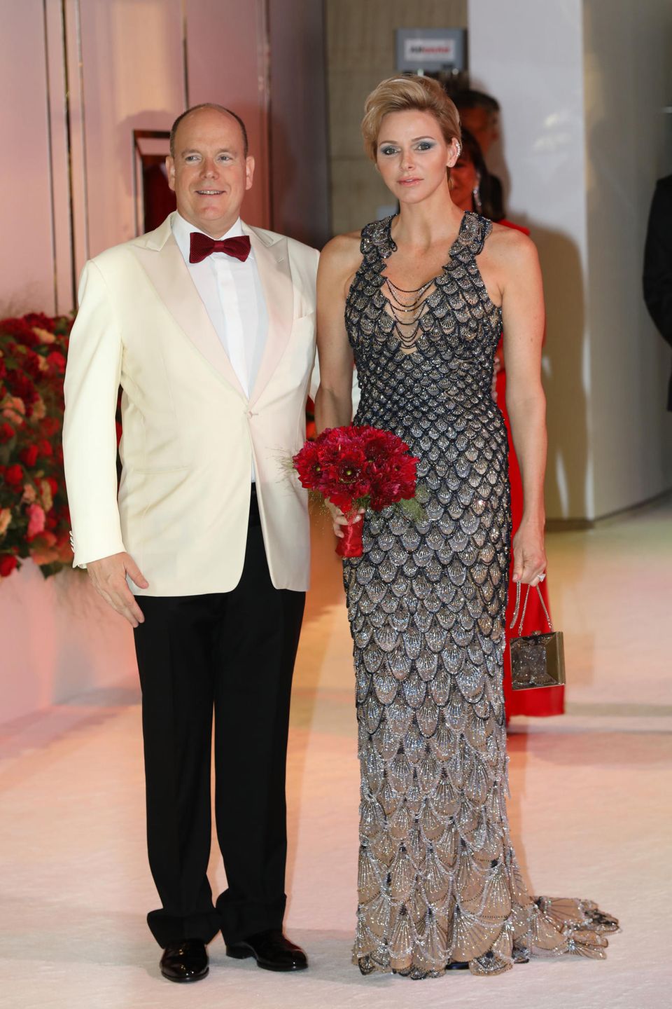 Zu Ehren des 70. Rot-Kreuz-Balls hüllt sich Fürstin Charlène in diese atemberaubende Robe von Atelier Versace und ist damit der Blickfang des Abends! Das Kleid mit seinem schönen Farbverlauf von Blau zu Gold erinnert dank seines schuppenartigen Designs an die Flossen einer Meerjungfrau. Zu Ehren des 70. Rot-Kreuz-Balls hüllt sich Fürstin Charlène in diese atemberaubende Robe von Atelier Versace und ist damit der Blickfang des Abends! Das Kleid mit seinem schönen Farbverlauf von Blau zu Gold erinnert dank seines schuppenartigen Designs an die Flossen einer Meerjungfrau.