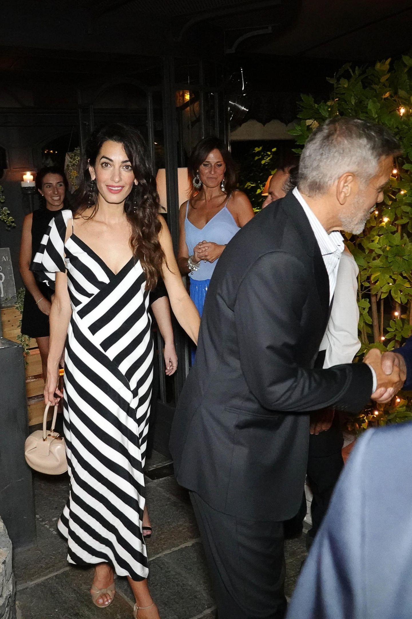 Dieses schwarz-weiß-gestreifte Sommerkleid von Amal Clooney würden wir ihr am Liebsten sofort vom Leib reißen. Das hübsche Midi-Kleid stammt von Michelle Mason und ist aktuell sogar im Sale zu bekommen (504 statt 845 Euro). Dazu kombiniert die Frau von George Clooney beigefarbene Accessoires und lange, schwarze Ohrringe. 