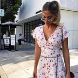 Zu ihrem sommerlichen Kleid mit rotem Blumenprint kombiniert Ann-Kathrin eine Tasche und Gürtel von Chanel. Rosa Nägel und ein hoher Pferdeschwanz geben dem Look das gewisse, süße Etwas. 