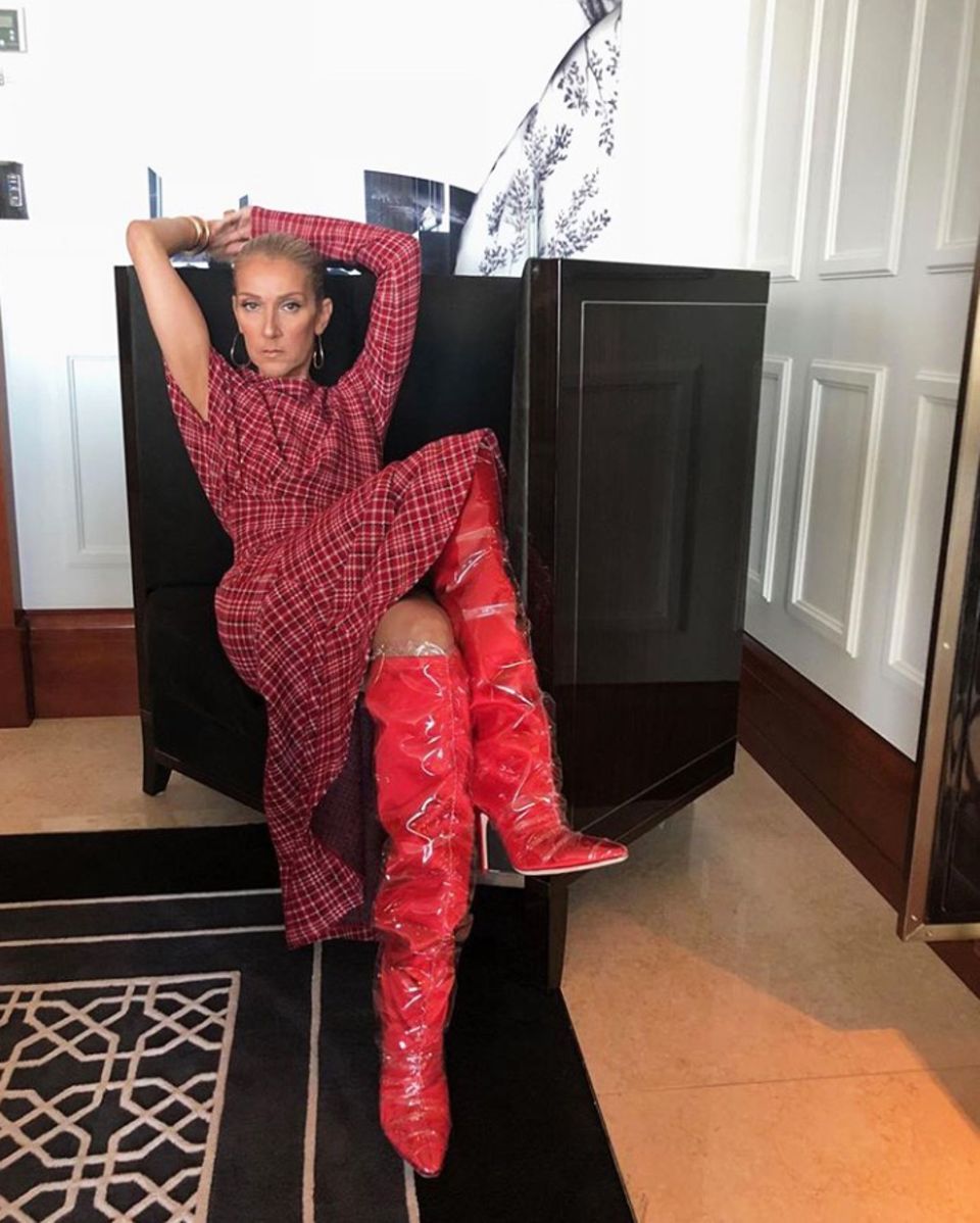 Diese Overknees brauchen einen Waffenschein! Zum roten Karo-Kleid von Calvin Klein kombiniert Céline Dion lackige Stiefel mit einem durchsichtigen Überzug. 