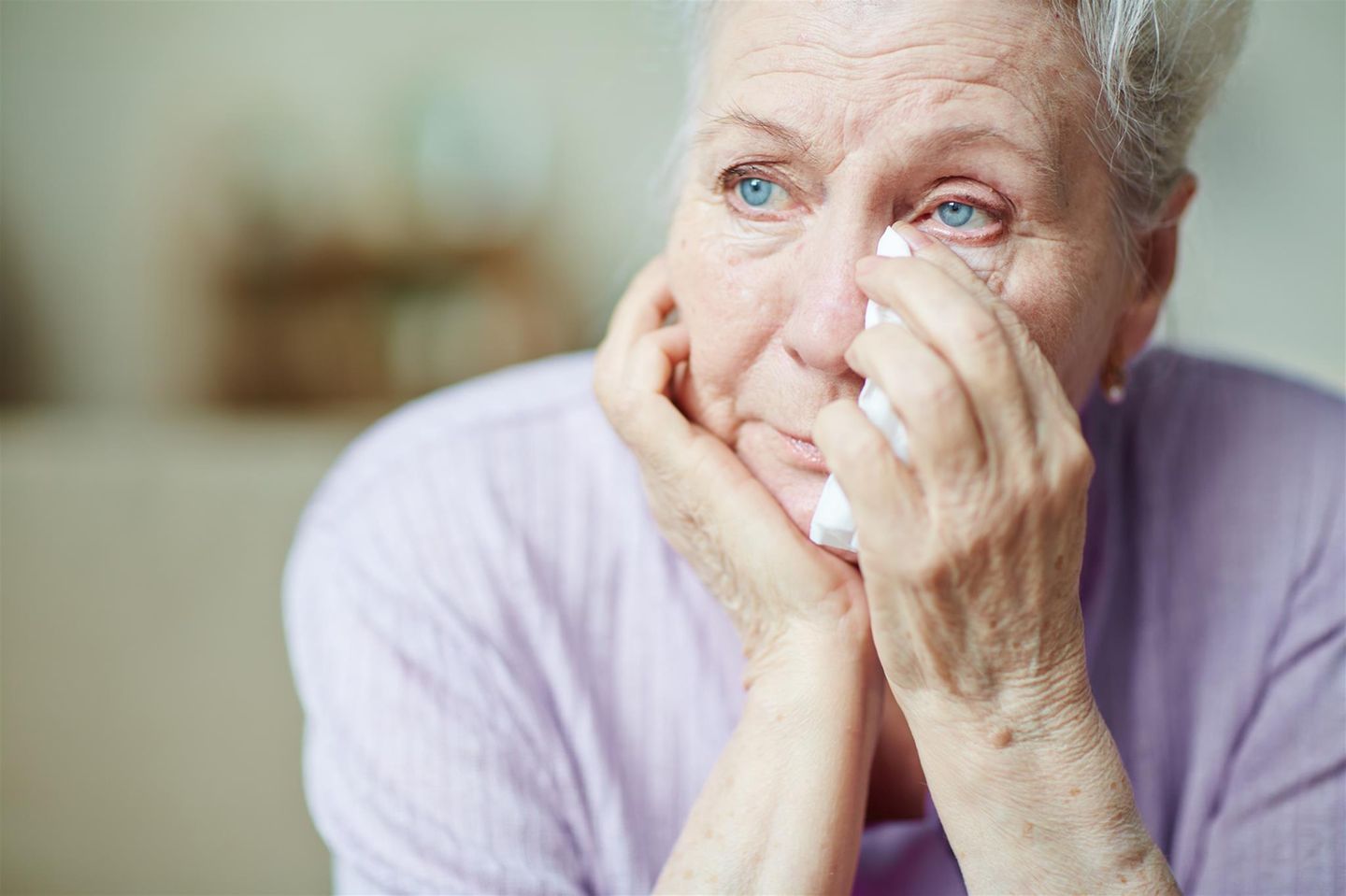 Symbolbild: Eine ältere Frau trocknet ihre Tränen. 