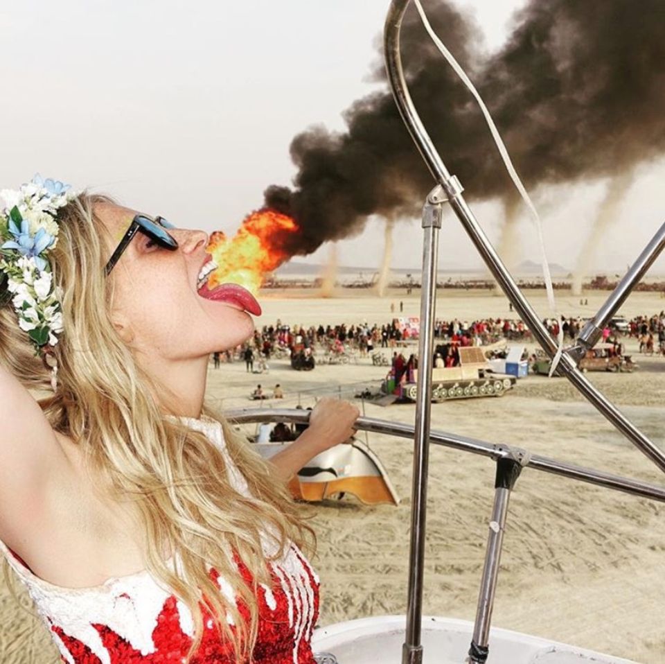 Model Poppy Delevingne überrascht Fans mit einem Throwback-Foto von ihr, auf dem es scheint, als würde sie Feuer speien. Auch wenn die Täuschung äußerst geschickt ist, tut Cara Delevingnes Schwester das natürlich nicht. Die schöne Blondine hat sich bloß im gekonnten Winkel vor ein weit entferntes Feuer bei dem Event "Burning Man" gestellt.