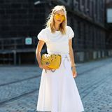 Akzente setzen: Bloggerin Leonie Hanne strahlt mit ihren gelben Accessoires mit der Sonne um die Wette. Zum All-White-Look kombiniert sie eine coole It-Bag von Marc Cain mit einer farblich passenden Sonnenbrille. 