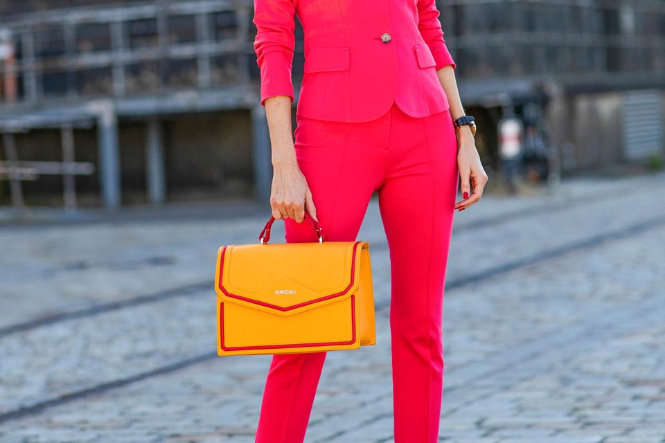 Color Blocking: Bloggerin Alexandra Lapp kombiniert zu einem pinkfarbenen Hosenanzug eine orangefarbene Handtasche und beweist, dass Mut zur Farbe sich lohnen kann. 