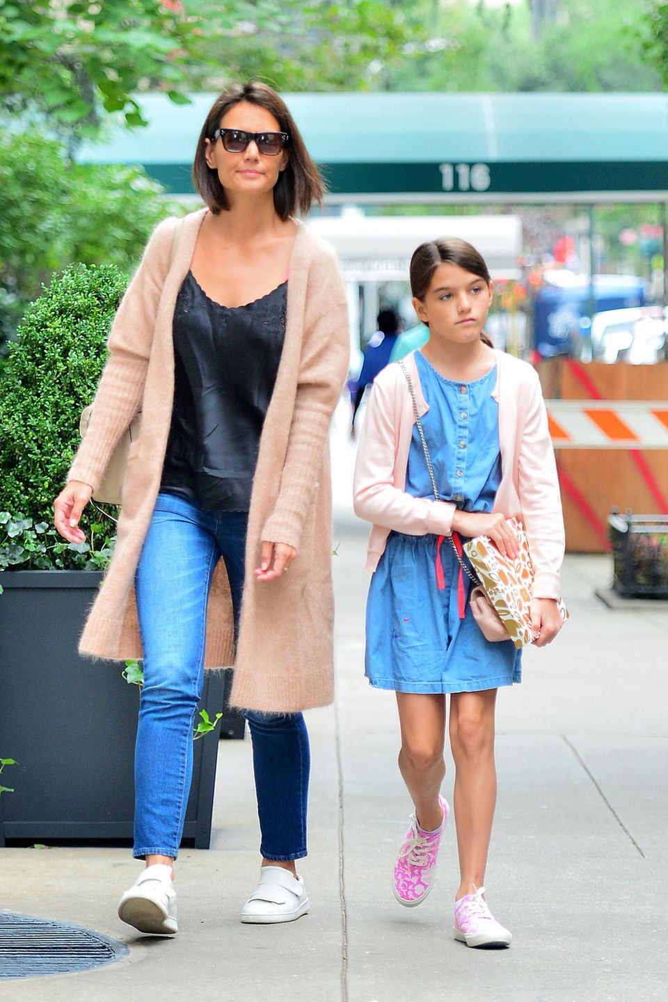 Katie Holmes und Suri Cruise genießen die sonnigen Temperaturen in New York: Beide kombinieren coole Jeans-Looks zu rosa Cardigans. Während Mama Katie auf weiße Sneaker setzt, trägt Suri geblümte Schuhe. 