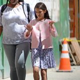 Suri ist stets top gestylt: In einem blauen Kleidchen mit Muster und einem rosa Jäckchen spaziert sie mit einer Nanny durch die Straßen New Yorks.