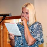 Hi hi hi Prinzessin Mette-Marit liest bei einer Veranstaltung in einer Schule ihre eigenen Aufsätze aus vergangenen Schultagen. Diese scheinen so lustig zu sein, dass sich Mette kaum halten kann, vor Lachen.