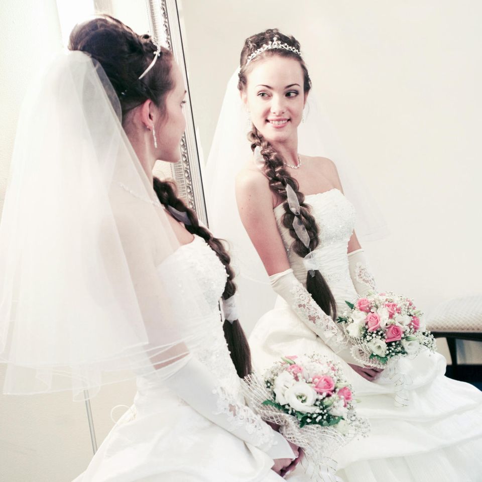 Symbolbild: Eine Braut betrachtet sich im Spiegel. 