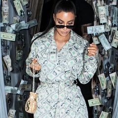Wieso sollte man Geld für Kleidung ausgeben, wenn man die Banknoten auch einfach in Form eines Mantels tragen kann? Kim Kardashian beweist mit diesem Outfit auf jeden Fall mal wieder ihre Vorliebe für ausgefallene Looks. Hier handelt es sich natürlich nicht um echte Geldscheine, sondern eine Vintage-Kreation von Designer Jeremy Scott, kombiniert mit Dollar-Overknees von Balenciaga. 
