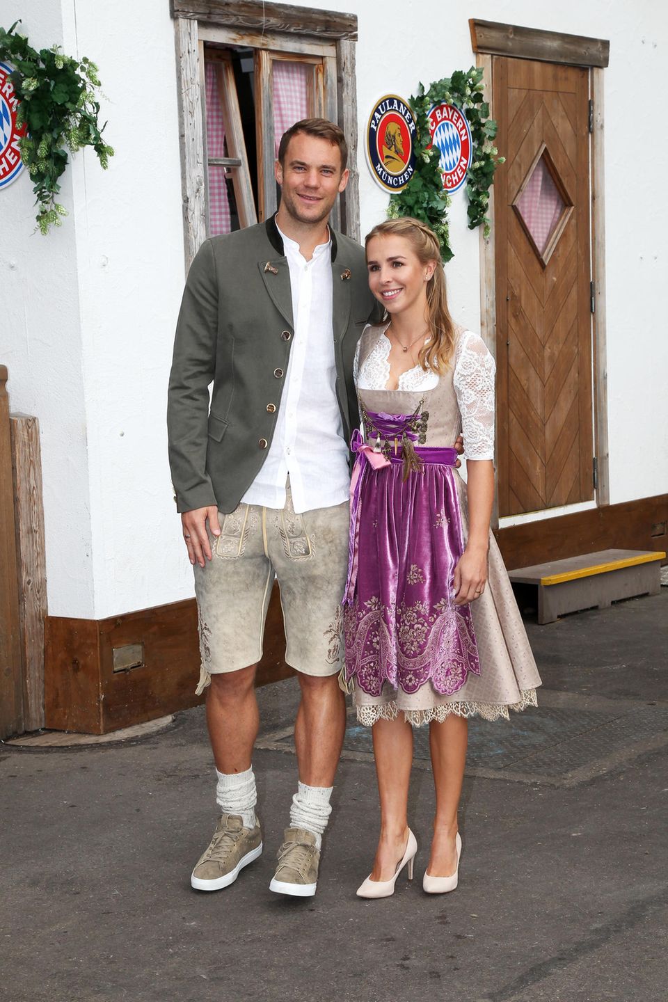 Auch Torwart Manuel Neuer und seine Frau Nina dürfen bei dem Besuch des FC Bayern Münchens auf der Wiesn nicht fehlen. Das Paar hat seine Looks farblich aufeinander abgestimmt. Lisa Neuer trägt ein beigefarbenes, edles Dirndl mit lilafarbener Samt-Schürze, Manuel trägt eine Lederhose in einem ähnlichen Beige-Ton. Auch Torwart Manuel Neuer und seine Frau Nina dürfen bei dem Besuch des FC Bayern Münchens auf der Wiesn nicht fehlen. Das Paar hat seine Looks farblich aufeinander abgestimmt. Lisa Neuer trägt ein beigefarbenes, edles Dirndl mit lilafarbener Samt-Schürze, Manuel trägt eine Lederhose in einem ähnlichen Beige-Ton.