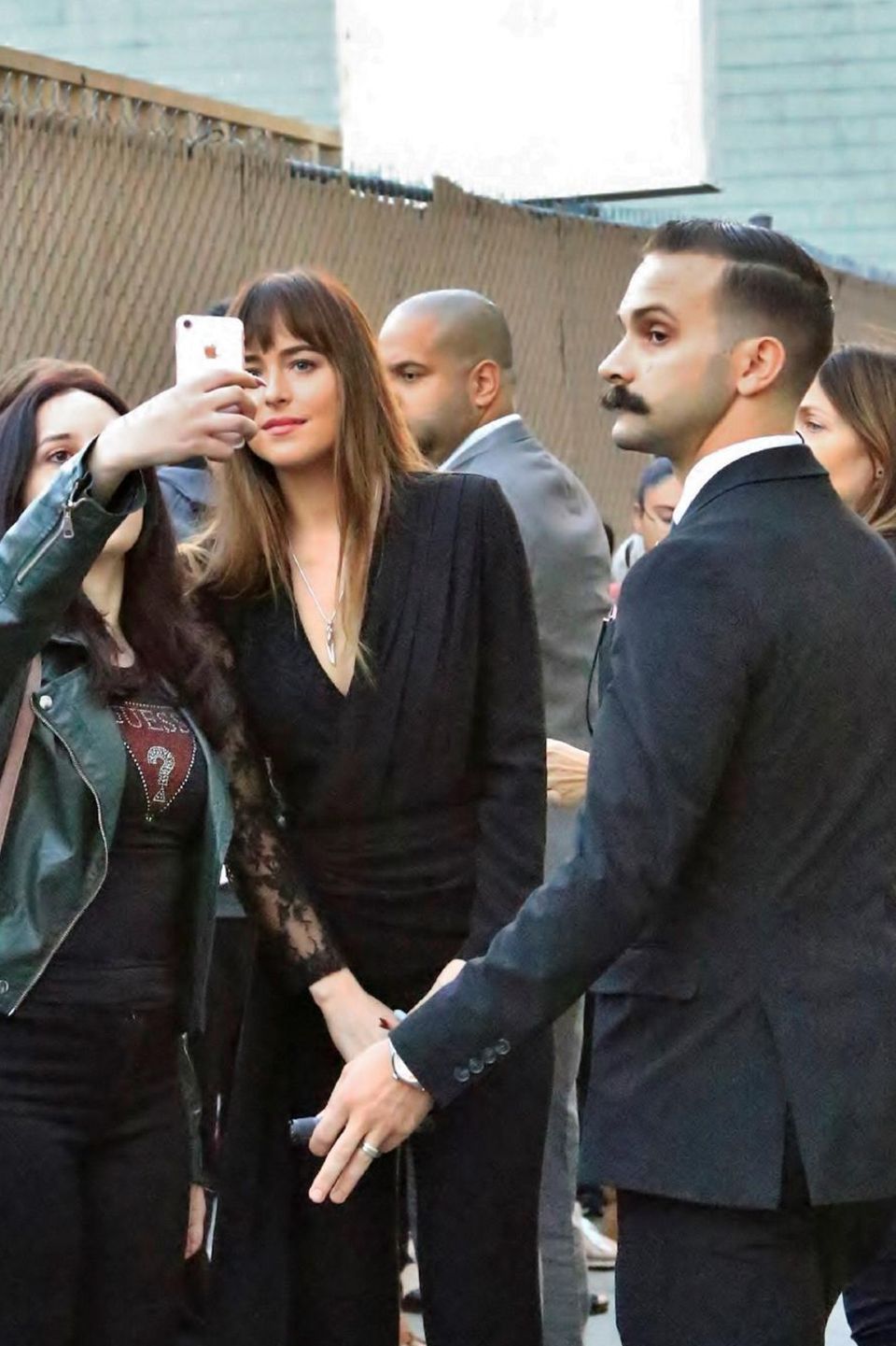 Beim Selfie-Knipsen mit den Fans zeigt sich Schauspielerin Dakota Johnson geduldig. Doch viel interessanter ist ihr Bodyguard, rechts im Bild. Attraktiv ist er ja, bis auf den buschigen Schnauzer ...