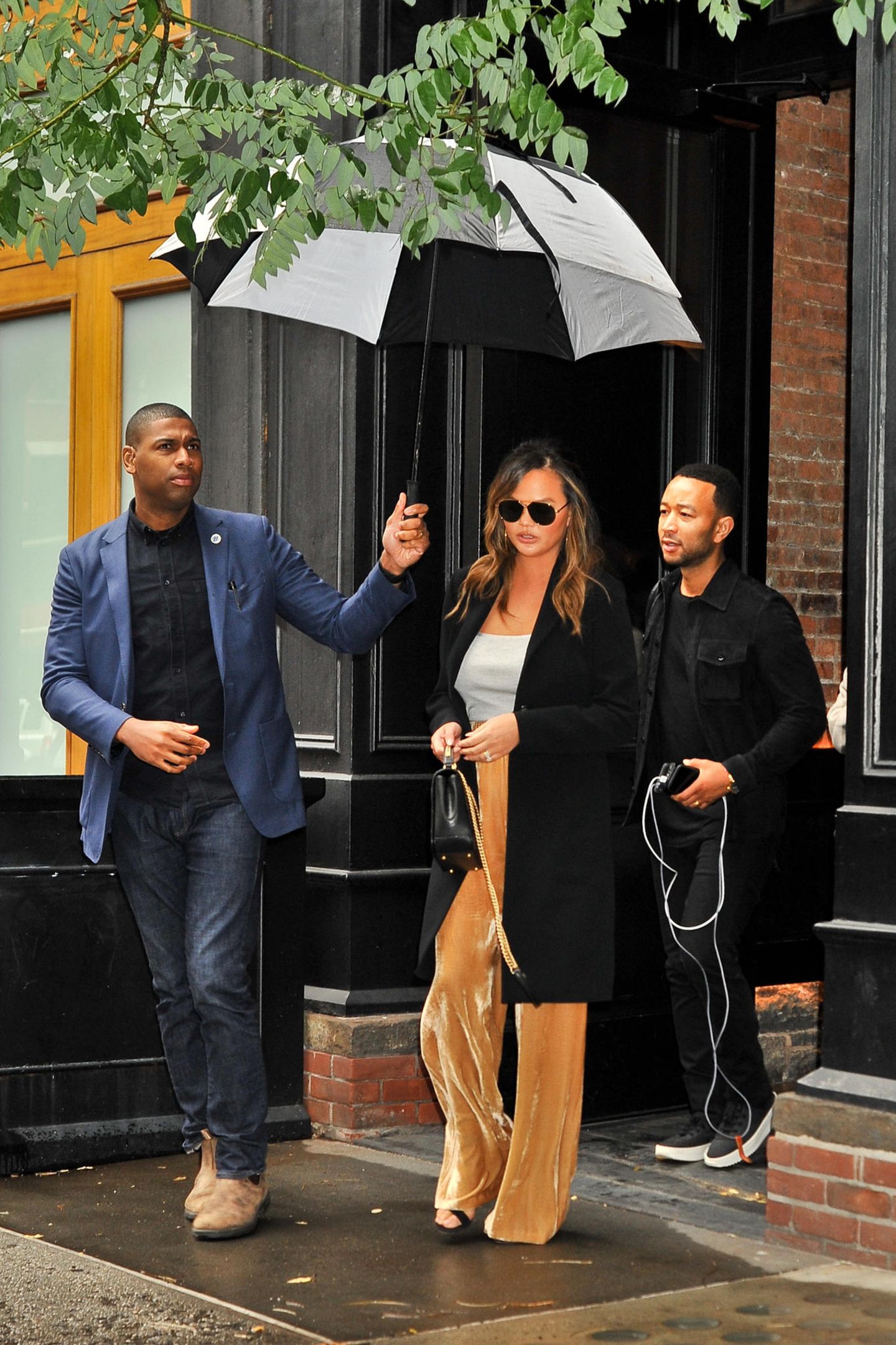 Bei Regenwetter den Schirm selber tragen? Nichts für Chrissy Teigen! Die lässt ihn sich von ihrem Bodyguard halten. 