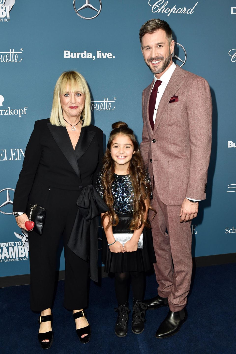 Die ehemalige Bunte-Chefredakteurin Patricia Riekel hat sich im schwarzen Anzug mit Schleifen-Detail sehr elegant verpackt, "The Voice Kids"-Gewinner Anisa Celik glitzert im niedlichen Pailletten-Look, und Moderator Jochen Schropp bringt im rötlich-grauen Anzug etwas Farbe auf den blauen Teppich. Die ehemalige Bunte-Chefredakteurin Patricia Riekel hat sich im schwarzen Anzug mit Schleifen-Detail sehr elegant verpackt, "The Voice Kids"-Gewinner Anisa Celik glitzert im niedlichen Pailletten-Look, und Moderator Jochen Schropp bringt im rötlich-grauen Anzug etwas Farbe auf den blauen Teppich.