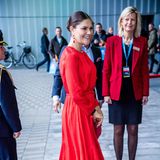 Zur Sicherheitsmesse SKYDD 2018 in Stockholm erscheint Prinzessin Victoria in einem wunderschönen Midi-Kleid mit fließender Struktur und kleinem Taillen-Gürtel in Knallrot. Passend dazu wählt sie farblich abgestimmte Pumps und eine Clutch - ebenfalls in Rot. 