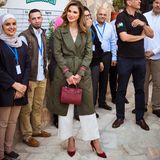 Auch bei diesem Look ist alles perfekt abgestimmt: Der herbstliche Rotton ihrer Schuhe findet sich auch in der edlen Tasche und den Ärmelschlaufen des Mantels wieder. Der khakifarbene Trenchcoat und die weiße Culotte runden den elegant-legeren Stil von Königin Rania ab. 