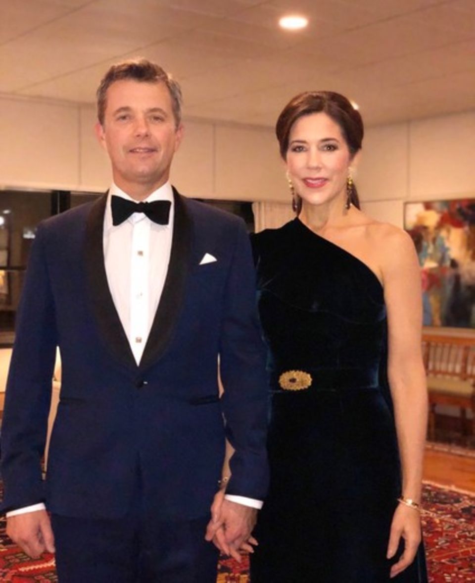 Prinz Frederik und Prinzessin Mary lassen es sich nicht nehmen, den 70. Geburtstag von Prinz Charles in London zu feiern. Für das Dinner wählt Mary ein langes One-Shoulder-Abendkleid aus dunkelblauem Samt. Ihre Taille wird durch einen gleichfarbigen Gürtel mit einer goldenen Brosche betont, den Brustbereich verzieren Volants. In Sachen Schmuck setzt die dänische Kronprinzessin auf lange Ohrringe und passende Armbänder, die Haare trägt sie hochgesteckt. Prinz Frederik wählt einen klassischen Smoking, passt sich aber der Farbwahl seiner Ehefrau an. Das royale Paar gibt sich zu diesem Anlass überraschend privat - Händchen haltend strahlen sie in die Kamera. Prinz Frederik und Prinzessin Mary lassen es sich nicht nehmen, den 70. Geburtstag von Prinz Charles in London zu feiern. Für das Dinner wählt Mary ein langes One-Shoulder-Abendkleid aus dunkelblauem Samt. Ihre Taille wird durch einen gleichfarbigen Gürtel mit einer goldenen Brosche betont, den Brustbereich verzieren Volants. In Sachen Schmuck setzt die dänische Kronprinzessin auf lange Ohrringe und passende Armbänder, die Haare trägt sie hochgesteckt. Prinz Frederik wählt einen klassischen Smoking, passt sich aber der Farbwahl seiner Ehefrau an. Das royale Paar gibt sich zu diesem Anlass überraschend privat - Händchen haltend strahlen sie in die Kamera.