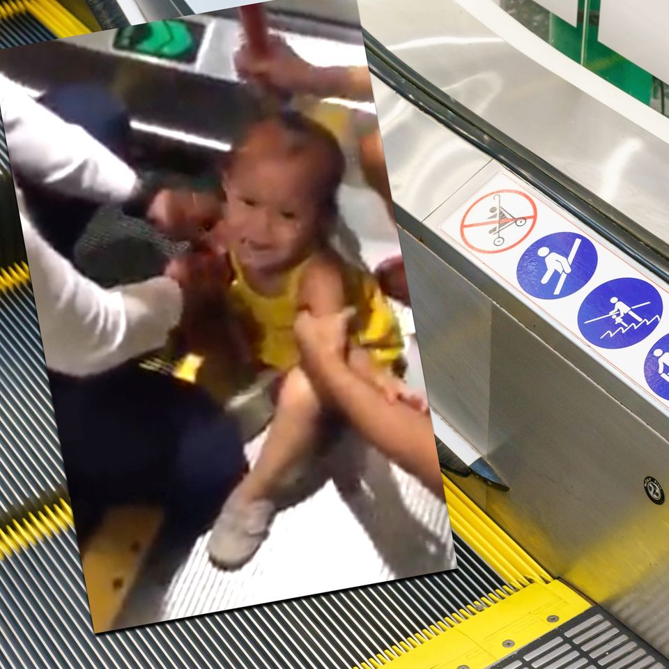 Kleines Mädchen klemmt sich die Finger in der Rolltreppe ein